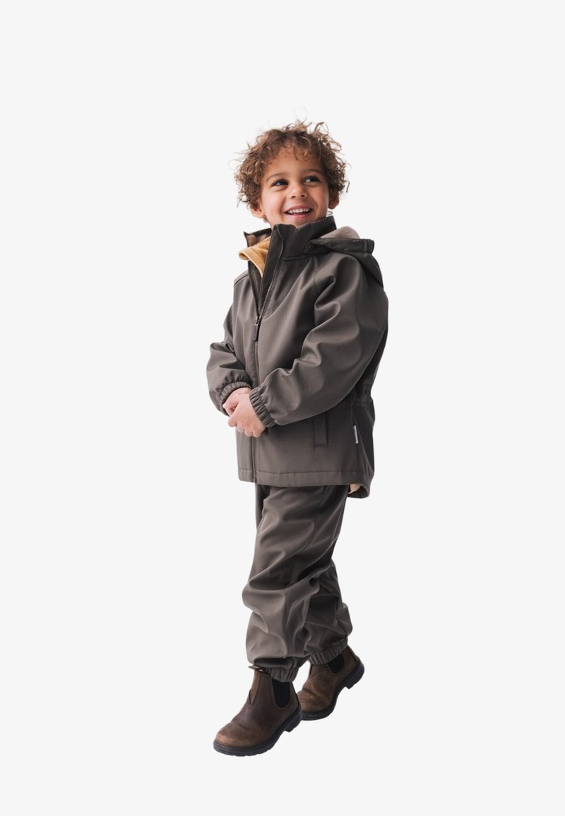 Wasserfester grauer Kindermantel mit beigem Innenfutter, passender Hose und braunen Gummistiefeln. Mit Reißverschluss vorne und Kapuze.