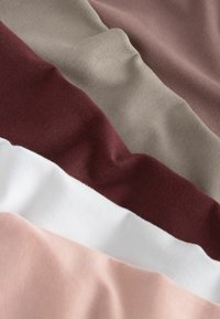 Měkké vzorky látek v béžové, mauve, vínové, bílé a světle růžové barvě, zobrazené přes sebe s viditelnou texturou a jemnými záhyby.
