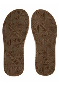 Brune gummisåler med en preget Quiksilver-logo og fjelldesign. Glatt tekstur med en sklisikker overflate.