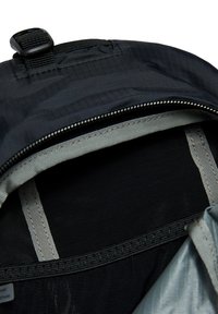 Interieur van een zwarte rugzak met een ritssluitingvak, grijze voering en van nylon materiaal. Heeft verstevigde naden en een bovenste draaggreep.