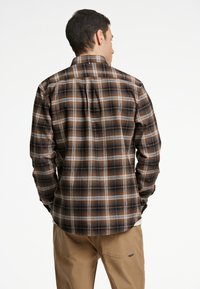 Herren Flanellhemd im braun-schwarzen Karomuster, mit spitzem Kragen und langen Ärmeln mit abgerundetem Saum. Regular Fit, weicher Stoff.