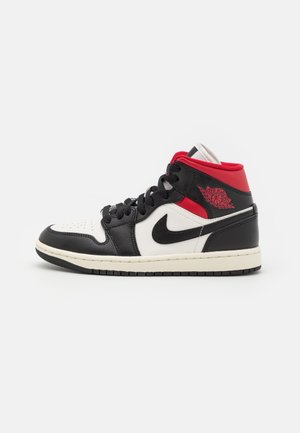 Wysokie sneakersy z czarnymi, białymi i czerwonymi skórzanymi panelami, czarnym logo Nike Swoosh, czerwonym logo Air Jordan oraz czarnymi sznurowadłami na białej podeszwie.