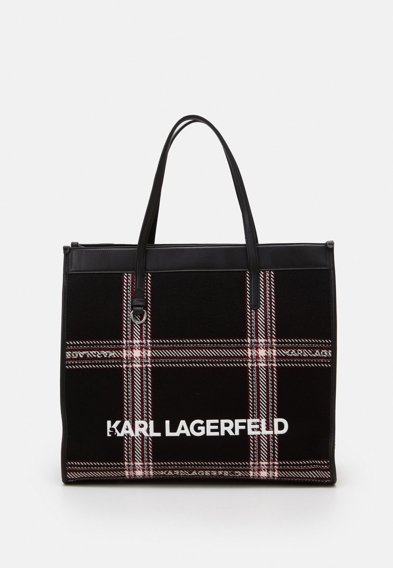 Svart tote-väska med rutigt mönster i röd och vit. Har svarta handtag i konstläder och en vit logotyp på framsidan.
