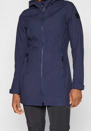 Person wearing a navy blue long-sleeve zip-up jacket with a hood and zippered side pockets, paired with black pants.