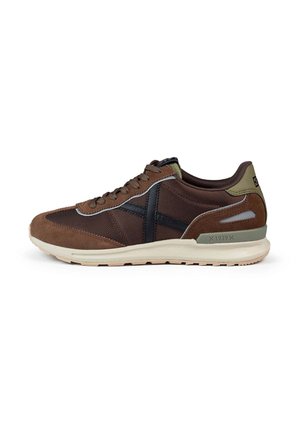 Chaussures de sport en daim brun et mesh avec des détails noirs, une semelle rembourrée et un accent vert au niveau du talon. Design classique à lacets.