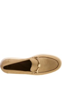 Beige Leder-Loafer mit glatter Oberfläche, ausgestattet mit einem goldfarbenen Kettenakzent über dem Vorderblatt und einer gesteppten Detail entlang der Kanten.
