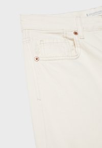 Beli teksas hlače z ravnim krojem, zasnovo s petimi žepi, opremo v bakreni barvi in kontrastnimi šivi.