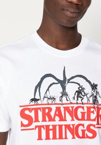 Champion Rochester CREWNECK STRANGER THINGS UNISEX - Triko s potiskem - white
