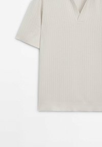 Beige strikket kortærmet top med V-hals, der har ribbet tekstur og en lige kant. Blødt stof øger komforten og alsidigheden.