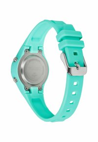 Montre Timex avec un bracelet en silicone turquoise, un dos en acier inoxydable argenté et une fermeture à boucle ardillon. Présente un design à sangle fendue.