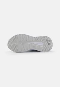 Suela blanca de zapatilla Adidas con patrones de agarre texturizados y el logo de Adidas cerca del talón sobre un fondo blanco liso.