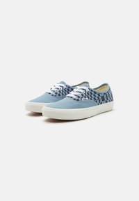 Blauwe canvas sneakers met een schaakpatroon aan de zijkanten, witte veters en rubberen zolen. Laag profiel ontwerp, lichtgewicht textuur.