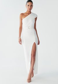 Weißes, einseitig schulterfreies Kleid mit Raffung, einem hohen Schlitz bis zum Oberschenkel und einem runden Gürtel-Detail. Weiches Material mit glatter Textur und schlanker Silhouette.