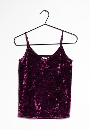 Camisole sans manches en velours, de couleur violet foncé, avec de fines bretelles réglables, suspendue à un cintre en métal noir sur fond blanc.