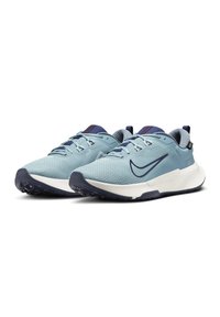 Baskets de sport bleu clair avec tiges en maille, accents marine, semelles texturées et semelles intermédiaires blanches contrastantes ; elles présentent des lacets et un détail de logo.