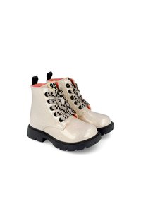 Botines metálicos brillantes en dorado claro con cordones negros, cuello acolchado y un interior rosa en contraste; suela negra resistente.