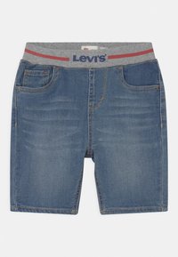 Vaaleansinisiä farkkushortsit, joissa on harmaa elastinen vyötärö, jossa on punaisia yksityiskohtia. Asusteena etutaskut ja suora leikkaus.