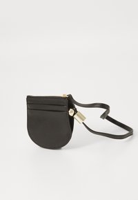 Black leather pouch with a rounded shape, gold zipper, and a detachable strap. Features front card slots and a smooth texture.
