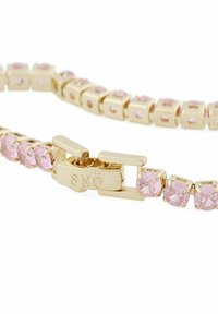 Guldtonad armband med rosa kubisk zirkonia i en fyrkantig infattning, med en gångjärnsklämma som visar varumärket "SNÖ."