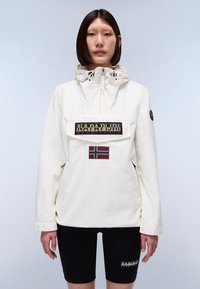 Weiße, mittellange Jacke mit Kordelzugkapuze. Verfügt über ein großes Logo-Patch auf der Vorderseite und eine norwegische Flagge. Zwei seitliche Taschen.