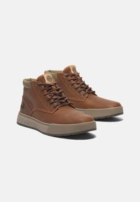 Braune Lederstiefeletten mit sandfarbenen Akzenten, ausgestattet mit einem gepolsterten Schaft, runden Schnürsenkeln und einer strukturierten Gummi-Sohle mit Logodetail.