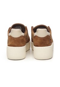 Bruine suède sneakers met een witte rubberen zool, gladde accenten op de hiel en een gestructureerde achterkant voor extra grip en stijl.
