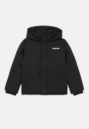 Black padded jacket with a hood, featuring the "Timberland" logo in white. Includes side pockets and ribbed cuffs. Smooth texture.