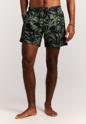 Zwarte zwemshorts met een groen tropisch bladpatroon, elastische tailleband en trekkoord. Twee zijzakken en een subtiel logodetail.