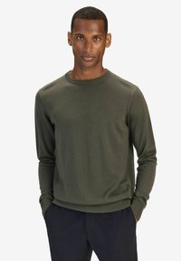 Mörkgrön, stickad tröja med lång ärm, rund halsringning och ribbade ärmslut. Enkelt design, inga synliga mönster eller accentuerande detaljer.