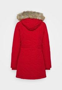 Abrigo parka rojo con una silueta ajustada, que cuenta con un borde de capucha de piel sintética, mangas largas y una textura suave. Sin bolsillos visibles.