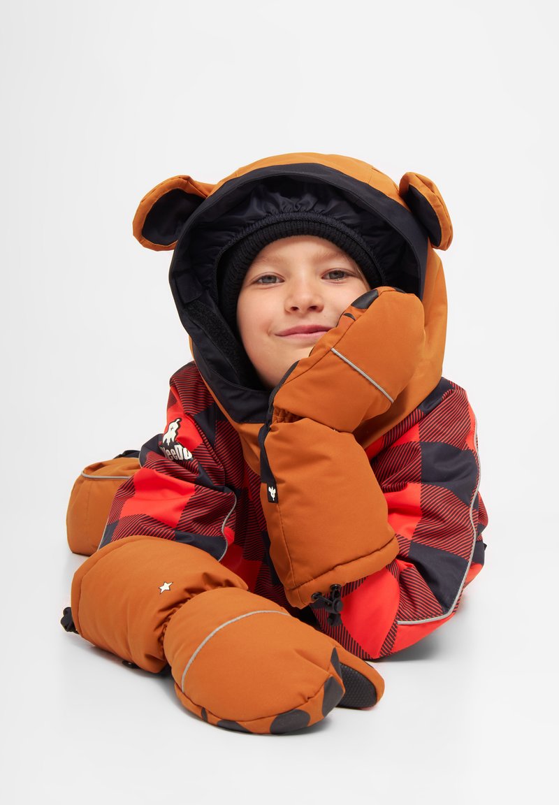 Orange huva jacka med björon, röd och svart rutigt mönster, med vadderade ärmar och matchande vantar för värme.