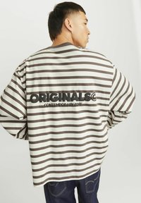 Üks suur, pika varrukaga särk kreemjas toonis pruunide horisontaalsete triipudega. Seljal on "ORIGINALS CONTEMPORARY EDIT" logo. Pehme puuvillane materjal.