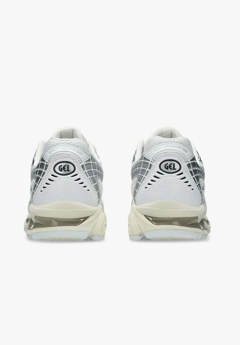 Un paio di scarpe da ginnastica bianche e grigie con ammortizzazione in gel, viste da dietro su uno sfondo bianco.