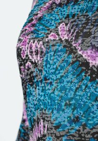 Multifarbener Stoff mit einem Blumenmuster in Blau-, Lila- und Schwarztönen, mit kleinen, erhabenen Verzierungen für Textur.