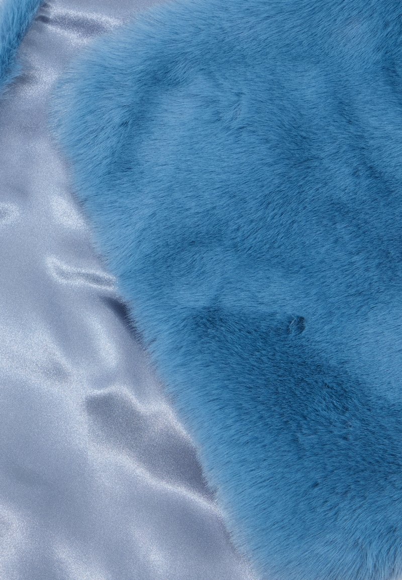 Tessuto di pelliccia finta blu con una texture morbida e soffice accanto a raso argentato lucido, evidenziando materiali e colori contrastanti.