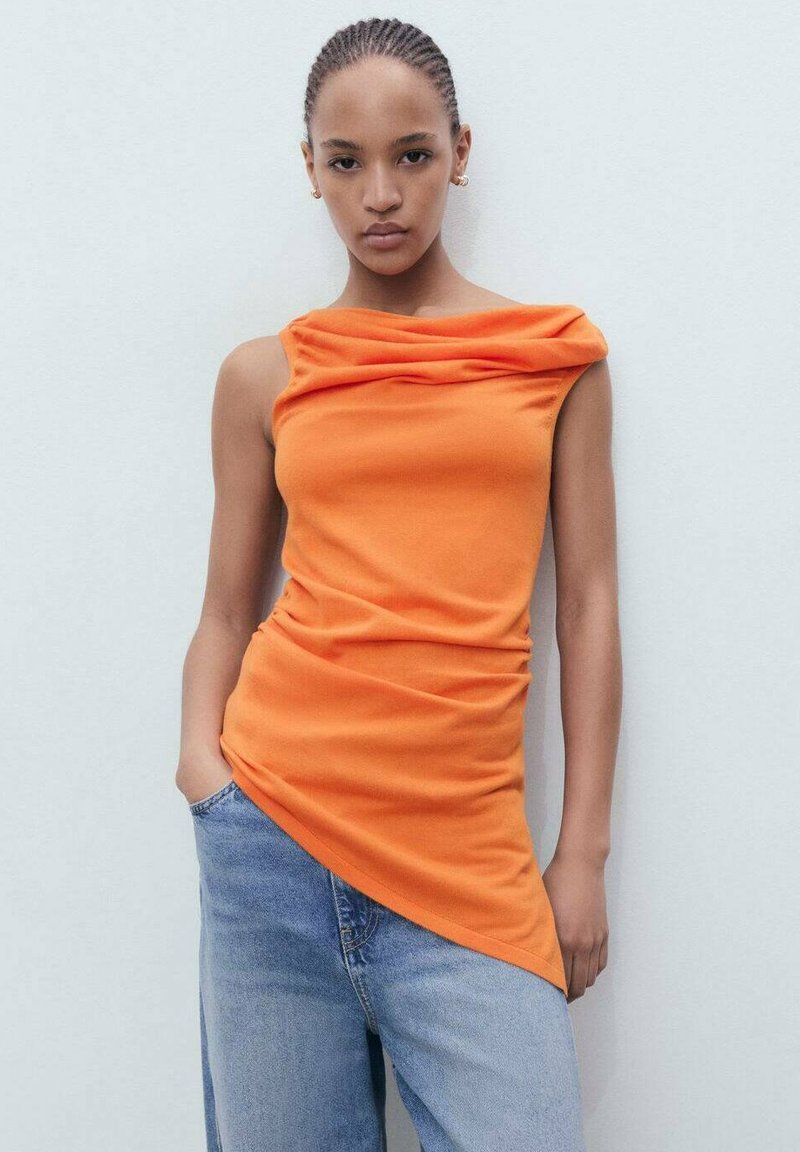 Oranje mouwloos topje met gerimpelde halslijn en asymmetrische zoom, gemaakt van zachte stof, gecombineerd met lichtblauwe wijde jeans.