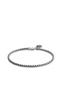 Sølvkjedearmbånd med sammenkoblede ledd, utstyrt med en krabbe-lås og en sirkulær charms med logo. Glatt metallisk finish.