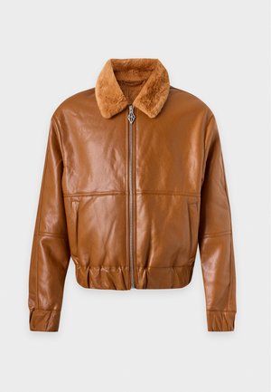 Un mannequin masculin porte une veste en cuir marron à col en peau lainée, une chemise noire, un jean noir délavé, des bottes et une casquette de baseball.