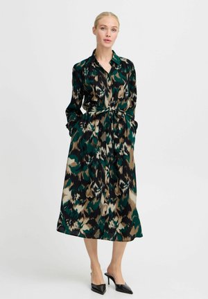 Abito lungo con bottoni in verde, nero e beige a stampa animale, con vita cinturata, maniche lunghe e tasche laterali. Texture setosa.