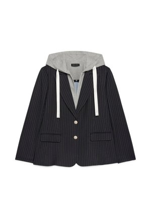 Blazer negro a rayas con dos botones frontales y bolsillos con solapa, superpuesto a una sudadera con capucha gris con cordones blancos.