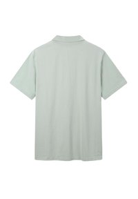 Polo shirt vert clair à manches courtes, avec un col, et une texture lisse et unie. Aucun logo ou motif visible.