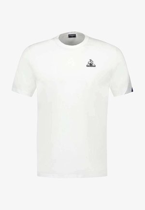 Camiseta de algodón blanca con mangas cortas, que presenta un logo negro en el lado izquierdo del pecho y un patrón texturizado en las mangas.