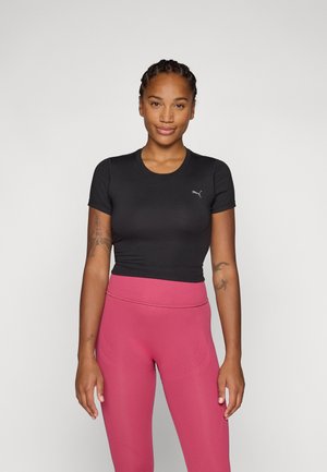 Svart kortermet tettsittende topp med rund hals og subtil logo-detalj, kombinert med høyt liv og elastiske rosa leggings.