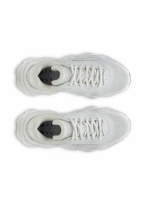 Baskets de sport blanches avec une tige en mesh, des accents texturés et une semelle épaisse et superposée. Présentent un logo rond noir sur la semelle intérieure.