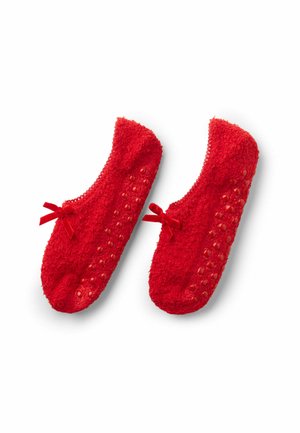 Rote fuzzy Hausschuhe mit strukturierter Oberfläche, die auf der Sohle mit Punkten für einen besseren Halt und kleinen Schleifen an der Vorderseite für einen Akzent ausgestattet sind.