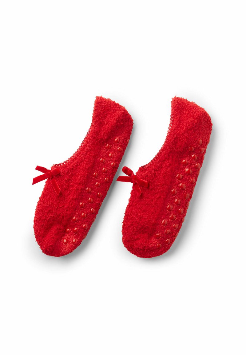 Pantofole rosse pelose con una superficie texturizzata, dotate di pois sulla suola per una migliore aderenza e piccoli fiocchi davanti come decorazione.