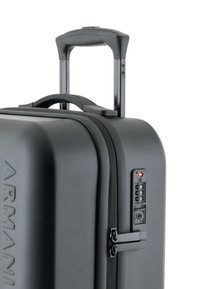 Maleta rígida negra con un acabado texturizado, doble cremallera, asa telescópica y cerradura de combinación integrada, con marca en relieve.