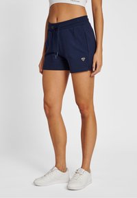 Námořnické šortky vyrobené z měkké látky, s elastickým pasem na šňůrku, bočními kapsami a malým logem na levé nohavici.