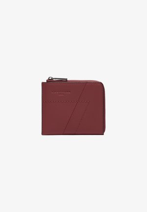 Portefeuille en cuir rouge au design minimaliste, featuring des coutures géométriques, un logo embossé et une fermeture éclair pour un accès sécurisé.