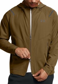 Brun huvtröja med dragkedja och en slät textur, har vinklade sömmar, grå accenter på axlarna och sidofickor.